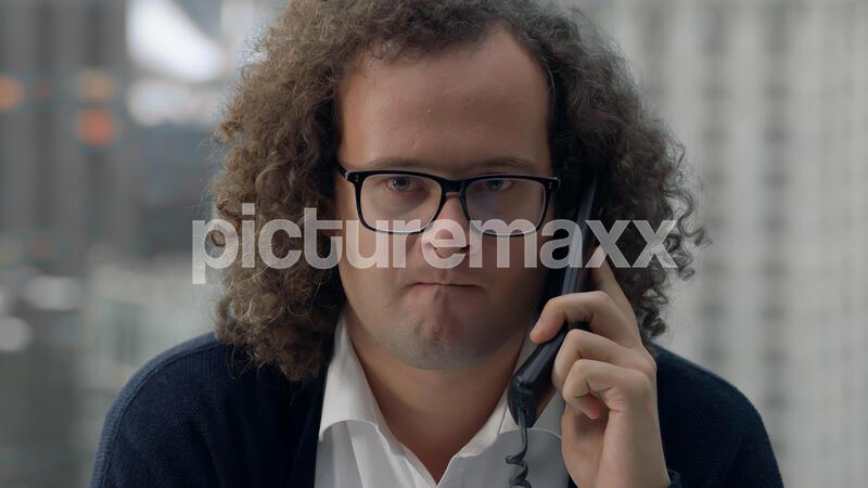 Crazy nerdy looking manager screaming into the phone during the call, negotiations gone wrong