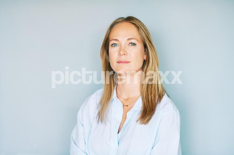Studio portrait of beautiful young woman on blue background