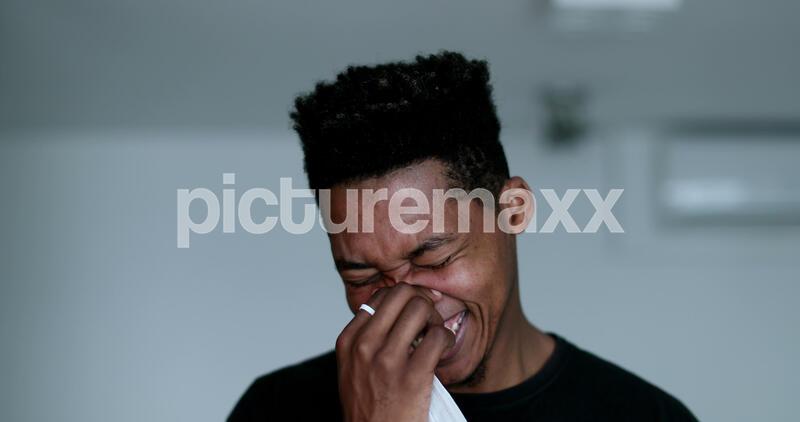 A young man laughs out loud spontaneously.